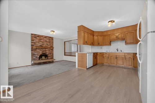 Kitchen with wood-finish cabinetry, white appliances, and laminate flooring - 2907 49 Street Nw, Edmonton, AB 
