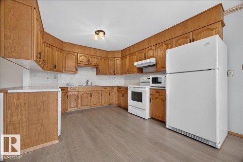 Kitchen featuring wood-finish cabinetry, white countertops, a white refrigerator, and wood-finish flooring - 2907 49 Street Nw, Edmonton, AB 