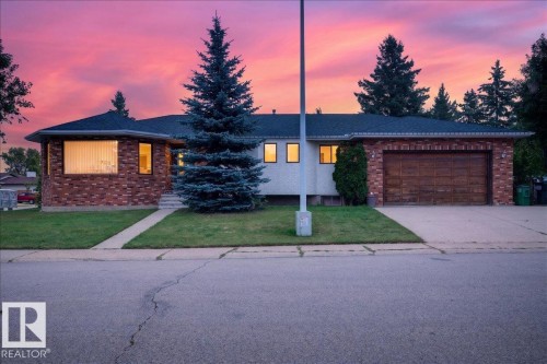 Brick facade with a dark shingle roof, attached garage with a wood-finish door, and concrete driveway - 2907 49 Street Nw, Edmonton, AB 