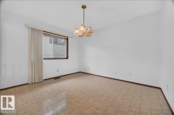 Recessed window with wood-finish trim, overhead chandelier, and tile flooring - 