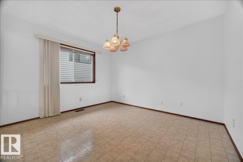 Recessed window with wood-finish trim, overhead chandelier, and tile flooring - 2907 49 Street Nw, Edmonton, AB 