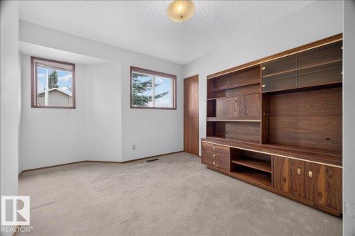 Built-in wood-finish cabinetry with glass-front display, multiple storage compartments, and integrated shelving - 2907 49 Street Nw, Edmonton, AB 