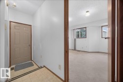 Tiled entryway with a neutral-toned door and wood-finish trim - 