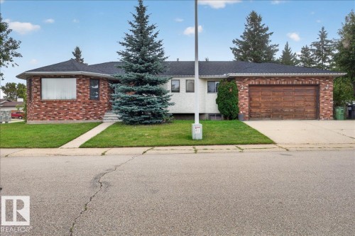 Brick exterior with a dark shingled roof, attached garage, and a concrete driveway - 2907 49 Street Nw, Edmonton, AB 