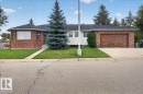 Brick exterior with a dark shingled roof, attached garage, and a concrete driveway - 2907 49 Street Nw, Edmonton, AB 