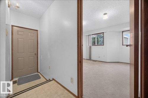 Tiled entryway with a neutral-toned door and wood-finish trim - 2907 49 Street Nw, Edmonton, AB 