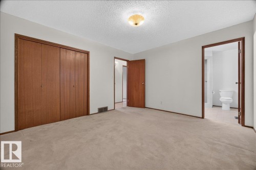 Neutral wall paint throughout, warm-toned wood doors, and light-colored carpeting - 2907 49 Street Nw, Edmonton, AB 