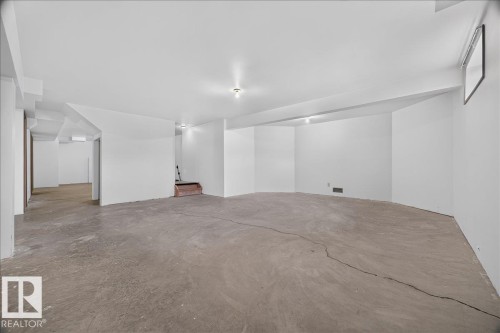 Expansive open area with concrete flooring, white walls, and recessed lighting - 2907 49 Street Nw, Edmonton, AB 