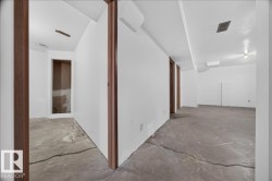 Open layout with concrete flooring, white walls, and wood-finish door frames - 