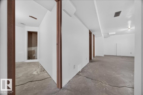 Open layout with concrete flooring, white walls, and wood-finish door frames - 2907 49 Street Nw, Edmonton, AB 