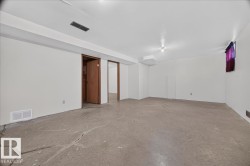 Spacious lower level with concrete flooring, recessed lighting, and white walls - 