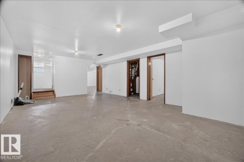 Expansive room featuring concrete flooring and white painted walls - 2907 49 Street Nw, Edmonton, AB 