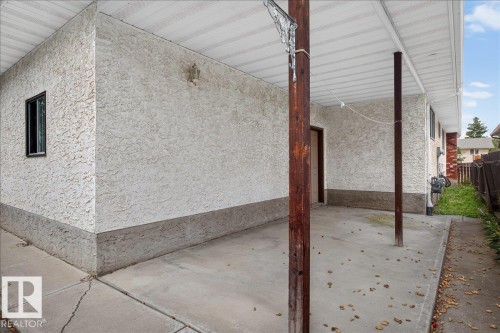 Carport with concrete flooring, stucco exterior, and a built-in outdoor light fixture - 2907 49 Street Nw, Edmonton, AB 