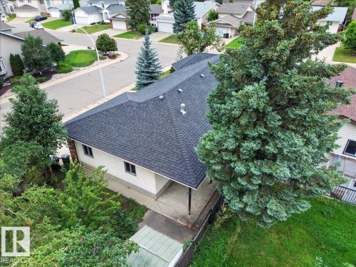 Shingled roofline, light-toned exterior siding, multiple windows, established trees, and a concrete driveway - 2907 49 Street Nw, Edmonton, AB 