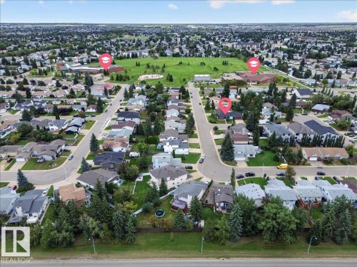 Aerial depiction of a residential neighborhood with numerous detached homes, mature trees, and a large green space - 2907 49 Street Nw, Edmonton, AB 