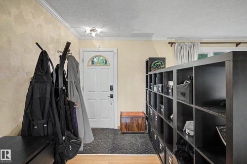 Entryway with crown molding, textured wall finish, and overhead flush-mount lighting - 11431 51 Avenue Nw, Edmonton, AB 