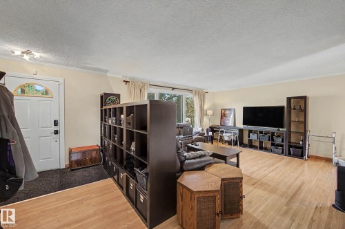 Hardwood-finish flooring throughout, crown molding, and a white entry door with an arched transom - 11431 51 Avenue Nw, Edmonton, AB 
