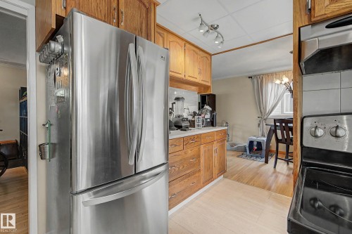 Kitchen featuring wood cabinetry, stainless steel refrigerator, and light wood-finish flooring - 11431 51 Avenue Nw, Edmonton, AB 