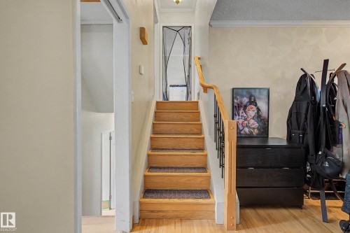Wood staircase with black metal balusters and wood handrail - 11431 51 Avenue Nw, Edmonton, AB 