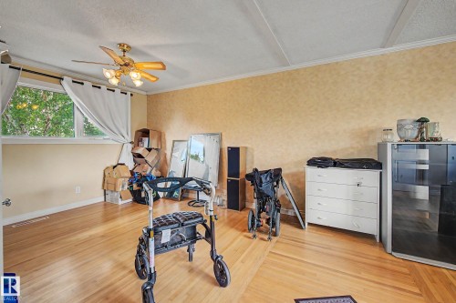Hardwood flooring, ceiling fan with integrated lighting, window with white curtains, textured wall finish - 11431 51 Avenue Nw, Edmonton, AB 