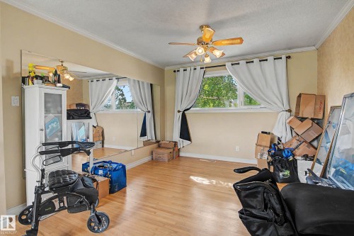 Hardwood-finish flooring, crown molding, built-in wall mirror, and a ceiling fan with integrated lighting - 11431 51 Avenue Nw, Edmonton, AB 