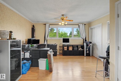 Hardwood flooring, crown molding, ceiling fan with integrated lighting, multiple windows, and a sliding closet door - 11431 51 Avenue Nw, Edmonton, AB 