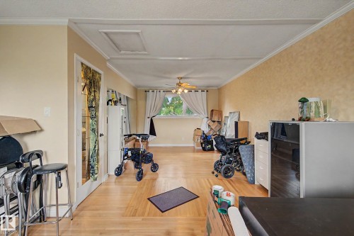 Wood-finish flooring with crown molding and a ceiling fan - 11431 51 Avenue Nw, Edmonton, AB 