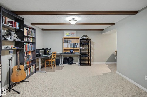 Recessed ceiling lighting illuminates the space, featuring exposed wood-finish beams - 11431 51 Avenue Nw, Edmonton, AB 