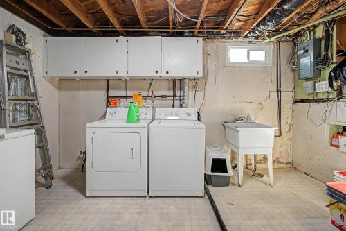 Upper cabinetry for storage, laundry sink, and a window for natural light - 11431 51 Avenue Nw, Edmonton, AB 