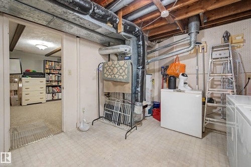 Unfinished basement space with exposed ductwork and ceiling joists, durable vinyl flooring, and a separate room with carpeted flooring - 11431 51 Avenue Nw, Edmonton, AB 
