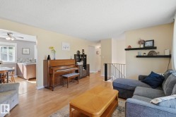 Wood-finish flooring throughout, living area with floating shelving, and a kitchen featuring a tile backsplash and ceiling fan - 