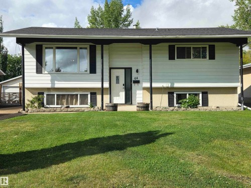 White siding exterior with black trim, presenting a split-level design - 64 Apache Crescent, Leduc, AB 