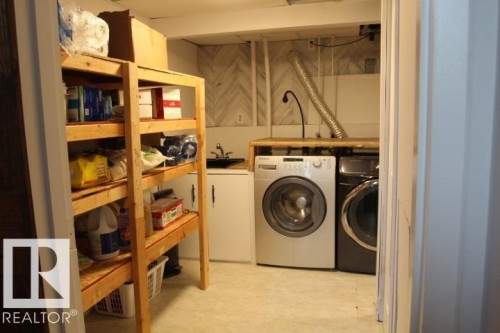 Laundry area with built-in shelving, a utility sink, and a countertop workspace - 64 Apache Crescent, Leduc, AB 