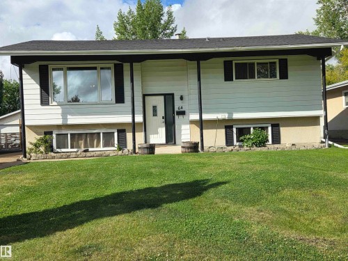 Two-story exterior with white siding, black shutters, and a dark shingle roof - 64 Apache Crescent, Leduc, AB 