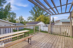 Expansive wood deck with a pergola, wood railing, and privacy screen - 