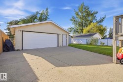Detached garage with a white panel door and exterior light fixtures - 