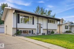 Split-level residence featuring white siding and stucco exterior finishes - 