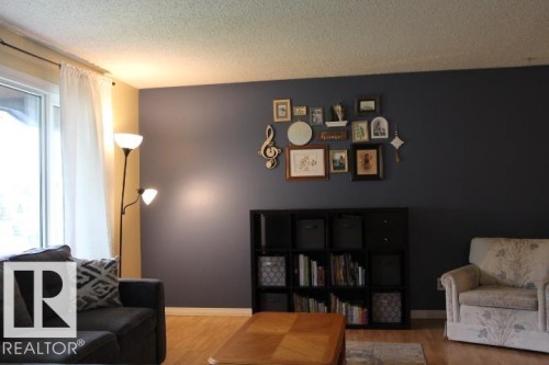 Wood-finish flooring with a contrasting dark accent wall - 64 Apache Crescent, Leduc, AB 