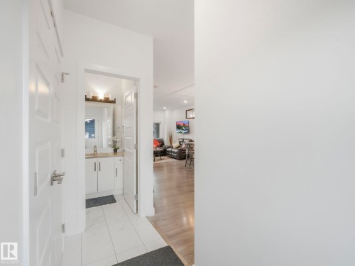 White paneled doors, polished chrome hardware, tiled flooring, wood-finish flooring, white vanity with integrated sink - 3807 Weidle Crescent Sw, Edmonton, AB 
