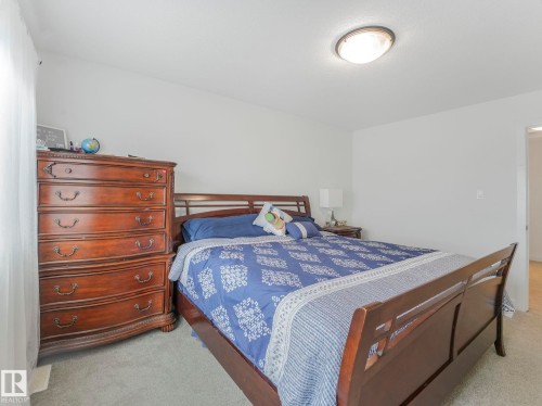 Carpeted bedroom with a flush-mount ceiling light fixture - 3807 Weidle Crescent Sw, Edmonton, AB 