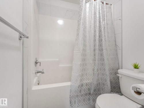 Bathtub with shower, chrome fixtures, and tiled surround - 3807 Weidle Crescent Sw, Edmonton, AB 