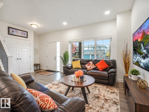 Recessed lighting, wood-finish flooring, white paneled doors, and a staircase with black railings - 3807 Weidle Crescent Sw, Edmonton, AB 