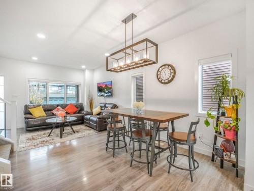 Open-concept living space featuring wood-finish flooring, recessed lighting, and multiple windows - 3807 Weidle Crescent Sw, Edmonton, AB 