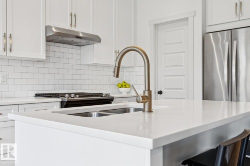 Kitchen island with a dual basin sink and gooseneck faucet - 22434 99A Avenue Nw, Edmonton, AB 
