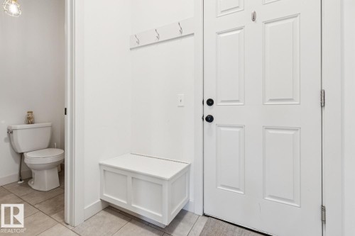 Panel door entry with dark hardware and a built-in storage bench - 22434 99A Avenue Nw, Edmonton, AB 