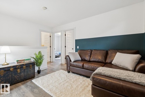 Wood-finish flooring with a white and deep teal wall treatment - 22434 99A Avenue Nw, Edmonton, AB 