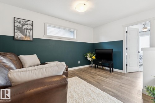 Wood-finish flooring, half-wall accent paint, white trim, and an overhead flush-mount light fixture - 22434 99A Avenue Nw, Edmonton, AB 
