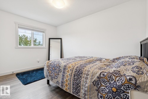 White walls, wood-finish flooring, white window trim, and a ceiling-mounted light fixture - 22434 99A Avenue Nw, Edmonton, AB 