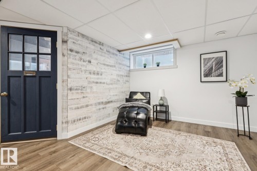 Wood-finish flooring, white walls, and a decorative wood-paneled accent wall - 22434 99A Avenue Nw, Edmonton, AB 