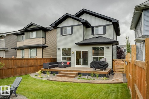 Expansive backyard featuring a manicured lawn, a multi-level wood-finish deck, and wood privacy fencing - 22434 99A Avenue Nw, Edmonton, AB 